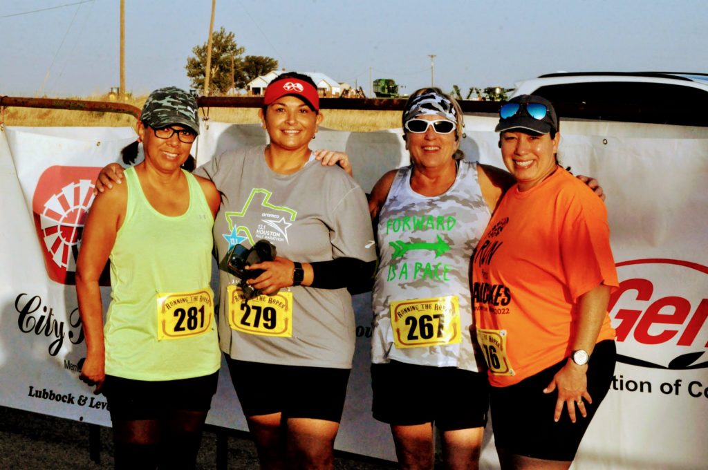 4 women celebrating together at race finish line.